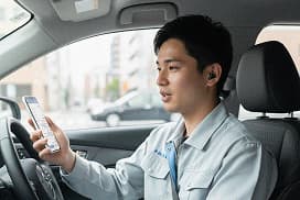 男性がスマホのAIに話しかける写真