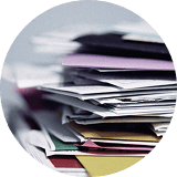 紙の日報や手書きの請求書が山積み…